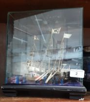 An Eastern white metal boat in glass case.