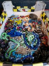 A box of costume jewellery including beads, necklaces, etc.