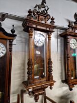 A walnut cased Vienna wall clock complete with weights, pendulum and key.