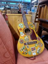 A vintage classical style acoustic guitar decorated with various European transfers.