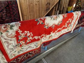 A Chinese wool carpet, red ground decorated with flowers, 183cm x 122cm approx