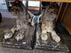 Two large stoneware recumbent lion garden ornaments.