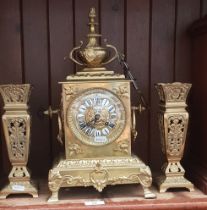 A French brass mantle clock and garnitures, Phillipe Fab, 66 Palais-Royal.