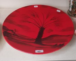 A Peggy Davis Ceramics red glazed charger decorated with palm tree, original artists proof.