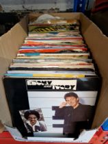 A box of 7" vinyl 45s records.