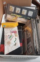 A box containing a stamp album, assorted loose stamps and first day covers.