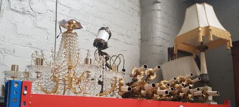 A collection of gilt metal wall lights, a glass drop chandelier, an onyx column table lamp with