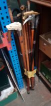 A bundle of approx 14 walking sticks including antler handles, metal eagle head, 3 with silver