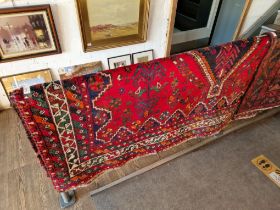 A vintage Middle Eastern hand knotted carpet, red ground, appx 290cm x 219cm