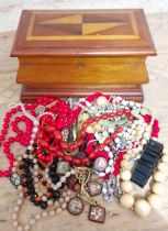 A parquetry inlaid jewellery casket and contents including marbled cherry beads, etc.