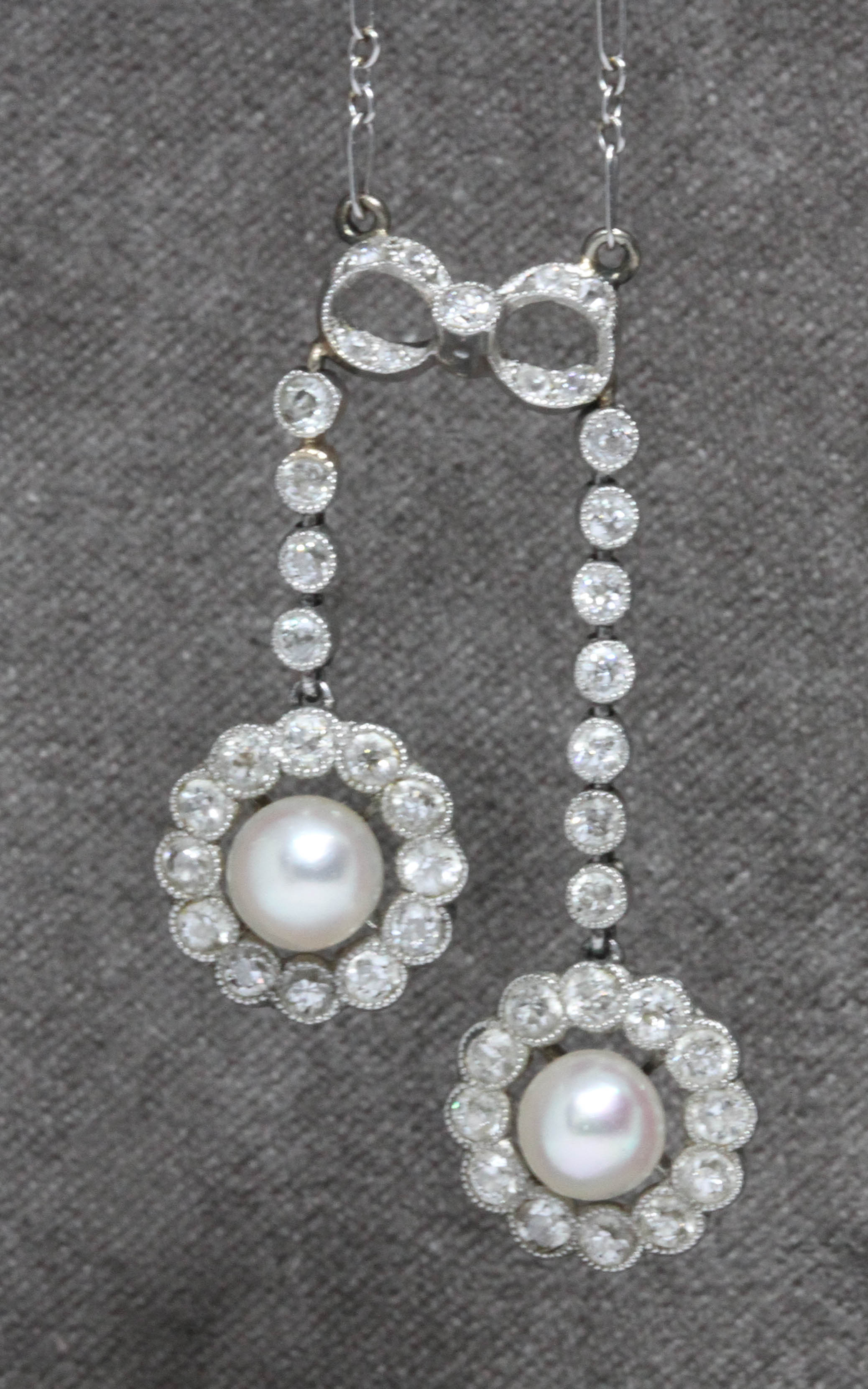 An early 20th century diamond and cultured pearl negligee necklace, the two drops with central pearl