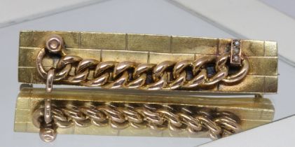 An antique yellow metal brooch modelled as a chain attached to a wall, unmarked, gross wt. 4.2g,
