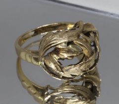 A yellow metal ring, the head formed from entwined leaves, indistinct foreign mark, weight 4.5g,