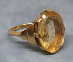 An Art Deco style citrine ring, the central oval mixed cut stone weighing approx. 13cts, band
