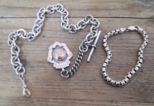 A silver watch chain and fob and a silver bracelet.