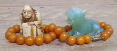 A bone netsuke, a jadeite jad carving and a bead necklace.