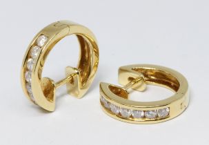 A pair of 18ct gold diamond earrings, of hoop design, each set with seven channel set diamonds,