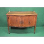 Mahogany serpentine fronted sideboard the top having brass finials over two doors opening to
