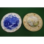 Large blue and white decorated cake plate together with one other wall plate decorated with building