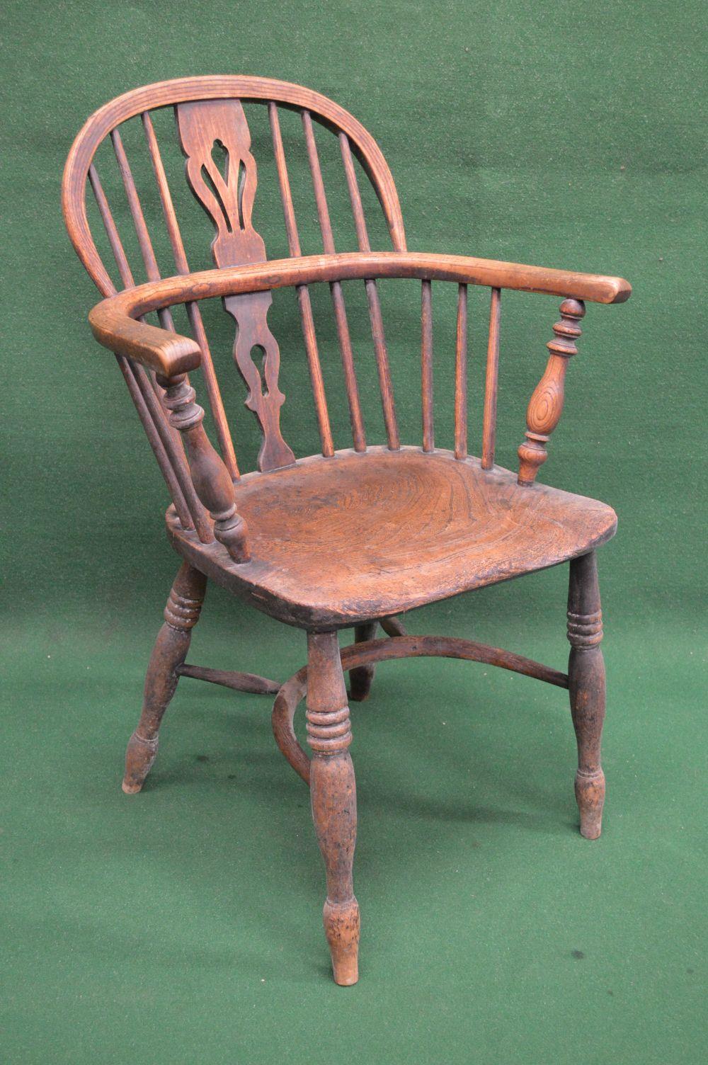 19th century elm comb back Windsor chair having pierced back splat and spindles over solid seat,