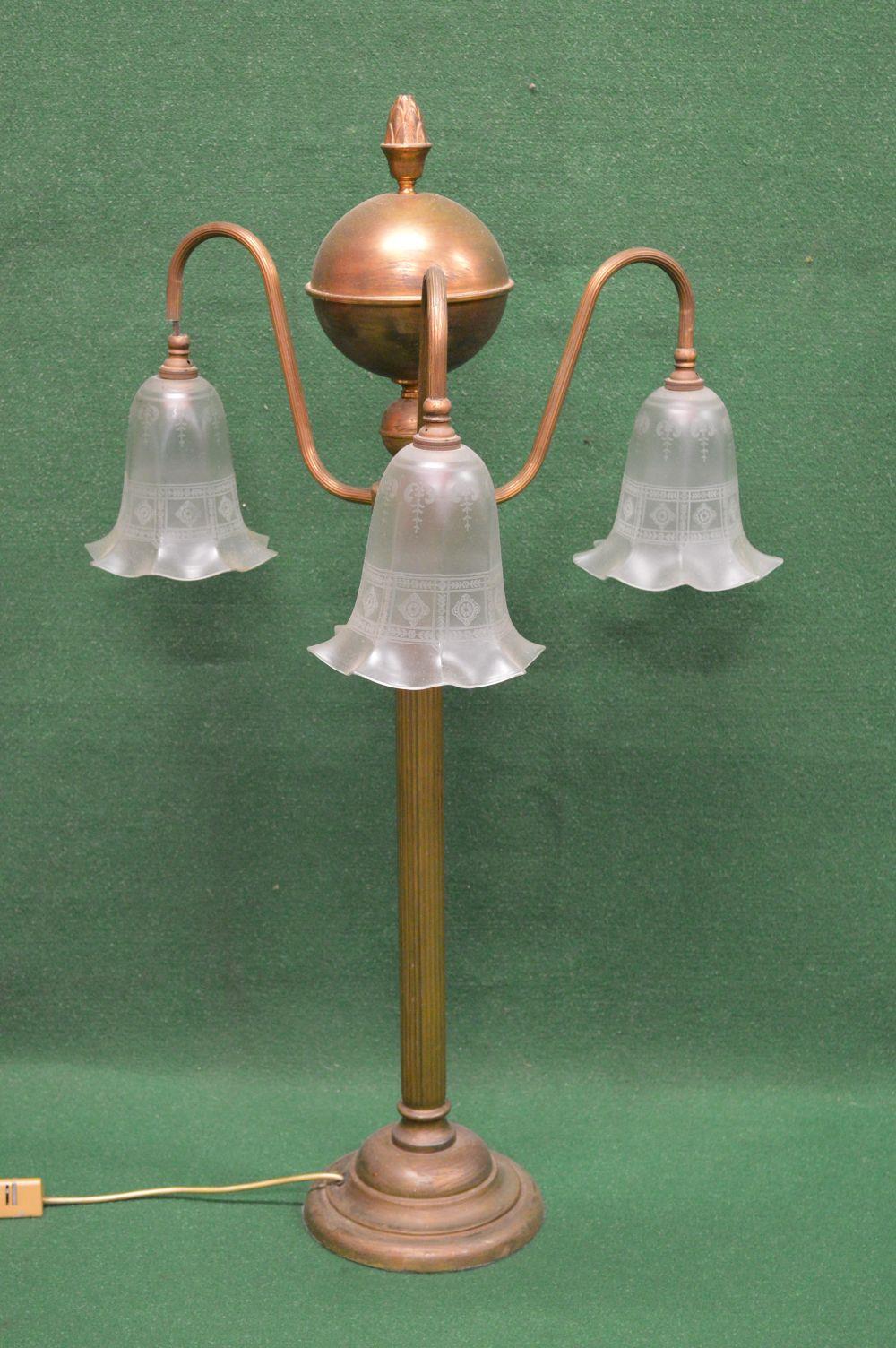 Brass three branch table lamp having reeded scrolled branches ending in down hanging frosted glass