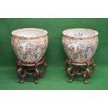 Pair of Oriental jardinieres decorated with panels of figures with further decoration of fish to