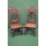 Pair of oak high back hall chairs having carved top rail supported by carved moulded uprights