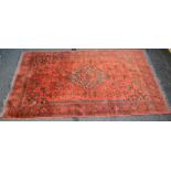 Red griound rug having black and cream pattern with end tassels, purchased in Afghanistan - 2.1m x