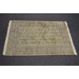 Pale green ground rug having cream, peach and black pattern with end tassels - 1.91m x 1.24m