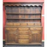 Oak dresser having canopy three shelf top, the lower shelf over row of five short drawers, having