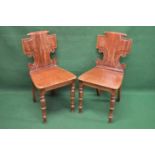 Pair of 19th century hall chairs having shaped solid backs over solid seats, standing on turned legs