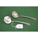 Pair of silver sauce ladles having Rat Tail pattern handles with crest engraving, hallmarked for