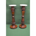 Pair of mahogany torchere's, each having circular marble tops supported on carved bulbous and