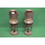 Pair of bronze two handled incense burners having raised decoration and standing on four legs