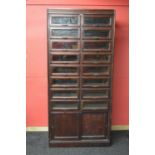 Dudley & Co. mahogany stained haberdashery cabinet having sixteen glazed drawers over two sliding