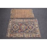 Blue ground rug having cream, red and blue pattern with end tassels - 1.42m x 1.02m together with