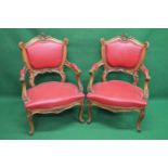 Pair of walnut carved show wood framed armchairs having padded backs and open arms leading to