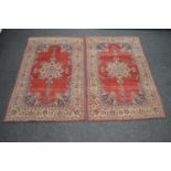 Pair of red ground rugs having blue, cream and red pattern with decorative floral borders - 2.05m