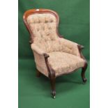 Victorian mahogany framed button back armchair having floral upholstery, standing on cabriole legs