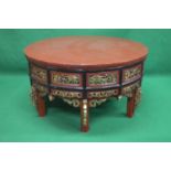 Red painted circular coffee table having pierced gilt painted side panels with black painted