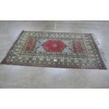 Patterned rug on a red and green ground with tassels - 3m x 2.04m Please note descriptions are not