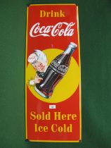 Vertical enamel advertising sign for Drink Coca Cola, Sold Here, Ice Cold, featuring an excited