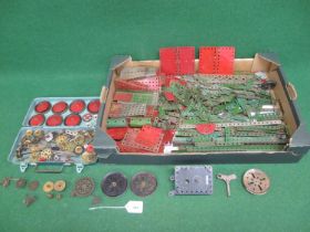 Box of loose red and green Meccano parts together with wheels, gears, axles etc and a clockwork