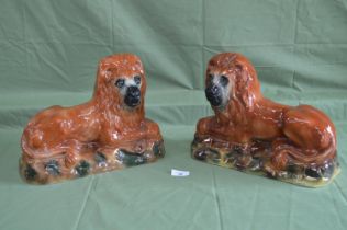 Pair of Staffordshire figures of recumbent lions with glass eyes - 9.5" tall Please note