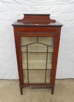 Oak glazed display cabinet with shaped raised back, bar glazed single door and standing on square