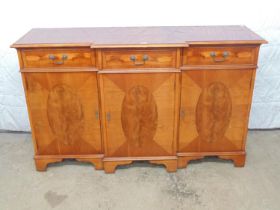 Yew wood breakfront sideboard with three drawers having swan neck handles over panelled doors,