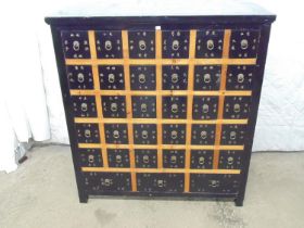Oriental style lacquered chest of thirty small and three short drawers, standing on square feet -