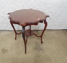 Mahogany two tier occasional table with shaped top and tier, standing on cabriole legs with carved