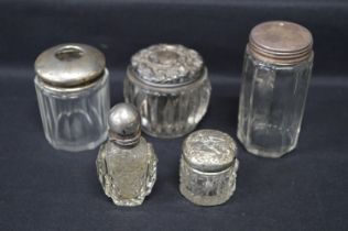 Group of three silver topped glass pots together with a small silver top hair tidy and a scent