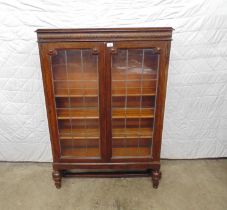 Oak display cabinet having a bar glazed door opening to reveal two adjustable and one fixed shelves,